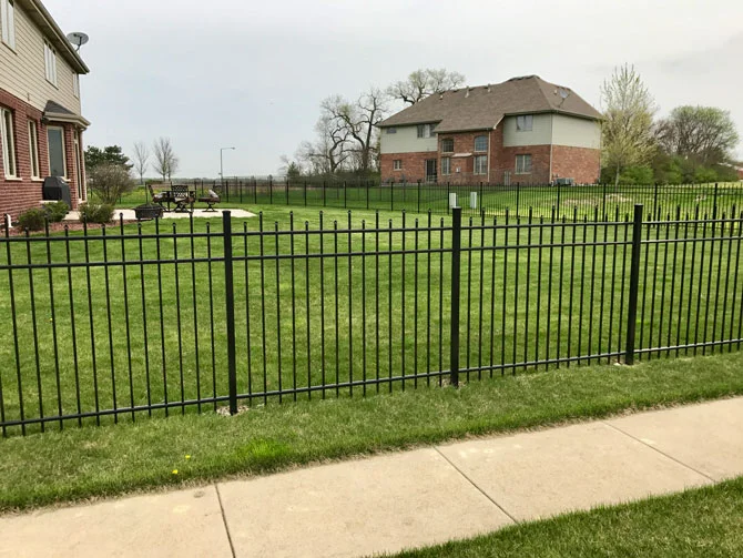 Precisely engineered aluminum fence installation along green lawn